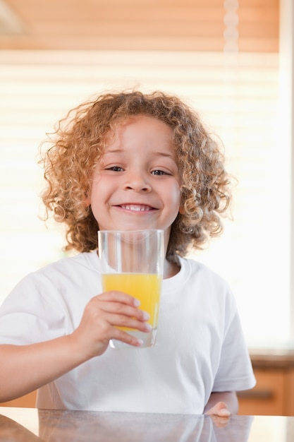 Glimlachend meisje die jus d&#39;orange in de keuken hebben