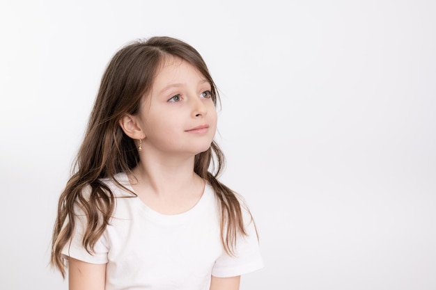 Glimlachend meisje kijkt weg tegen een witte achtergrond