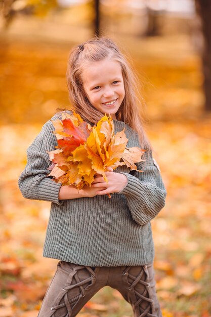 Foto glimlachend meisje met bladeren in de herfst