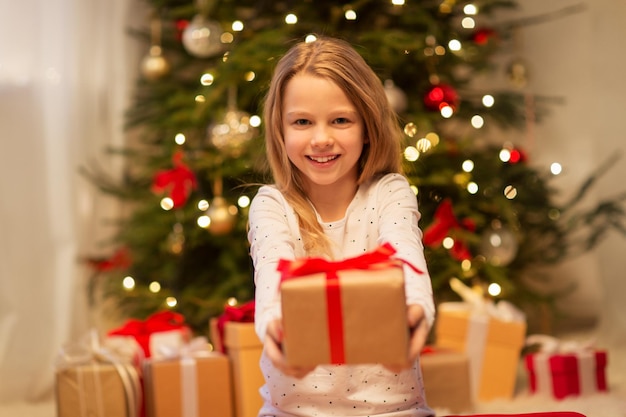 glimlachend meisje met kerstcadeau thuis