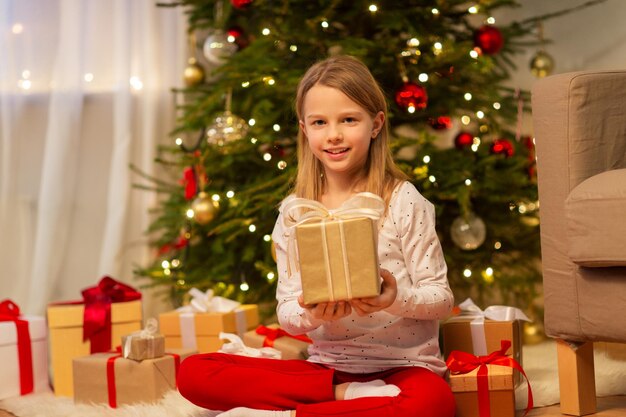 glimlachend meisje met kerstcadeau thuis