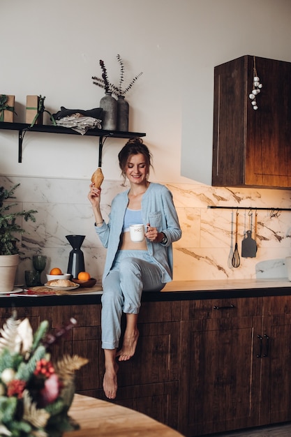 Glimlachend meisje met koffie en croissant. kerstochtend