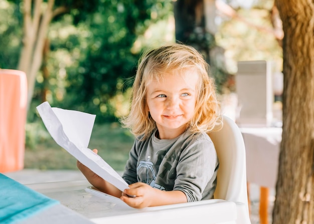 Glimlachend meisje met papier in het park.