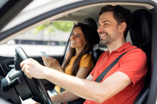 Glimlachend millennial paar zitten in luxe auto vrouw met smartphone