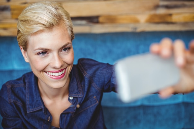 Glimlachend mooi blonde die een selfie spreken