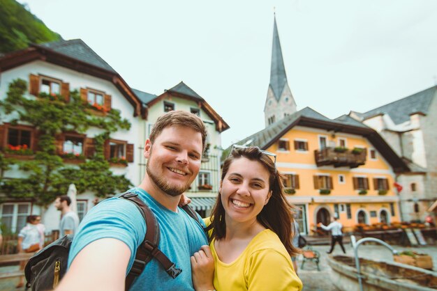 Glimlachend mooi paar dat selfie neemt op het centrale plein van de stad Hallstatt