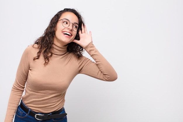 glimlachend, nieuwsgierig naar de zijkant kijkend, luisterend naar roddel of een geheim afluisterend