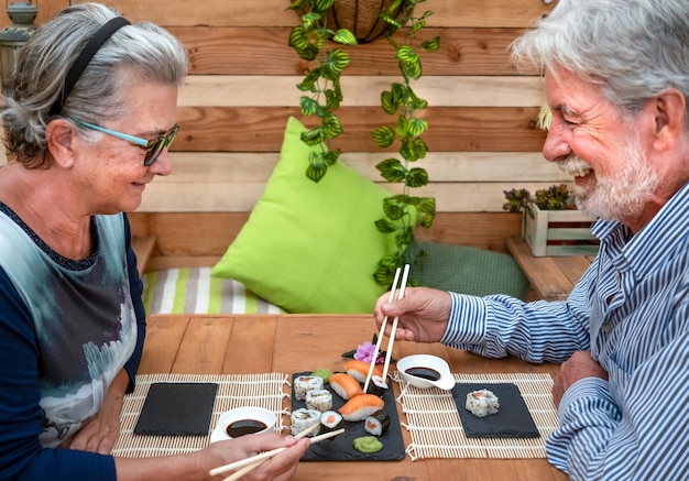 Foto glimlachend ouder echtpaar eet aan tafel.