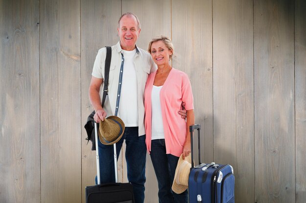 Foto glimlachend ouder paar dat op vakantie gaat tegen houten planken