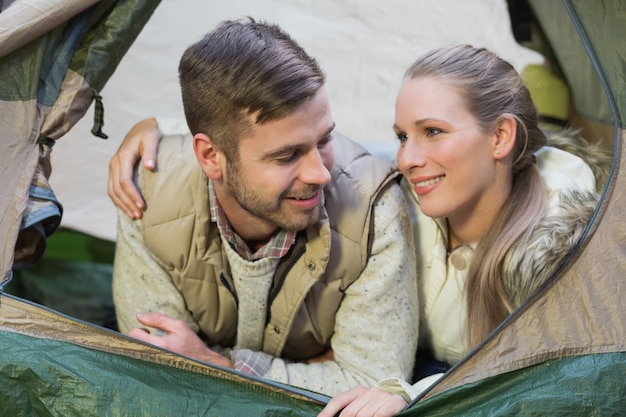 Foto glimlachend paar dat in tent na een stijging ligt