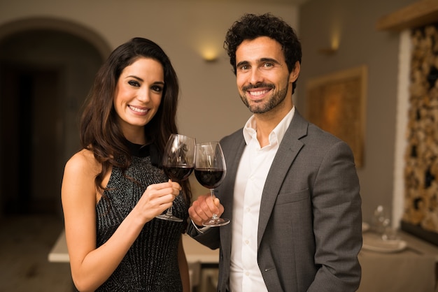 Glimlachend paar dat wijnglazen roostert