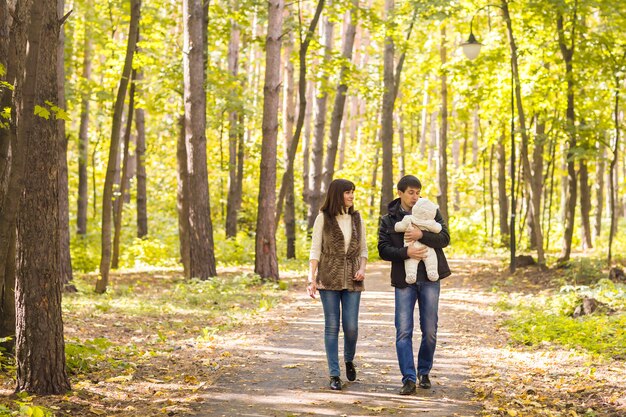 Glimlachend paar met baby in de herfstpark