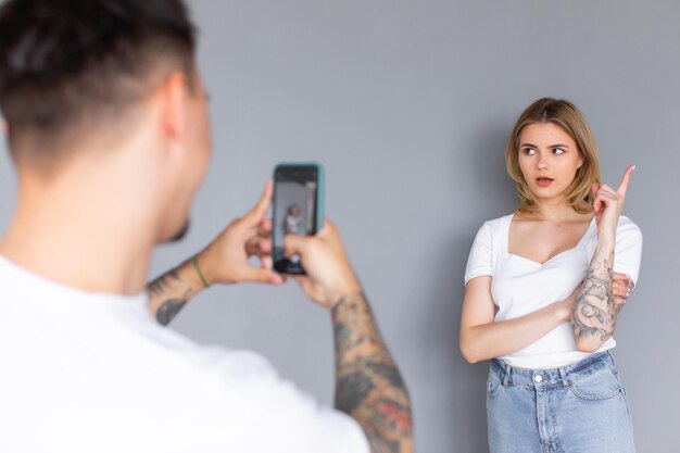 Glimlachend paar met behulp van telefoons in studio Geïsoleerde donkere achtergrond