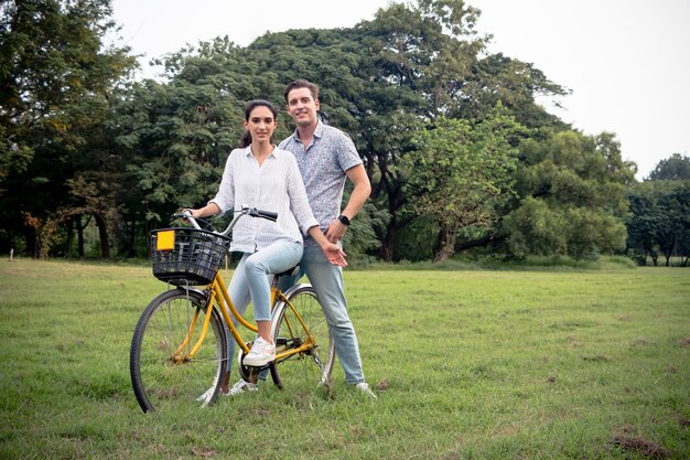 Glimlachend paar op de fiets in het park op een zonnige zomerdag