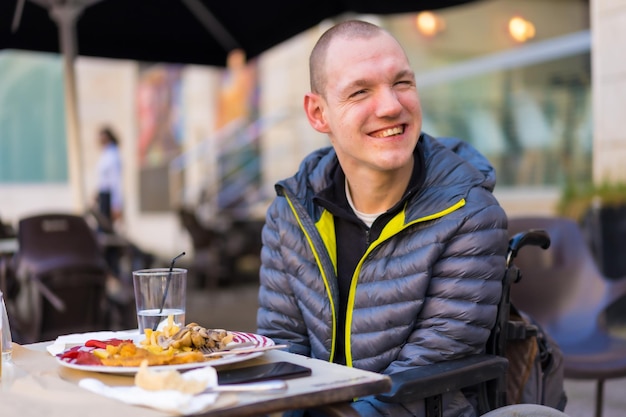 Glimlachend portret van een gehandicapte persoon in een rolstoel in een restaurant