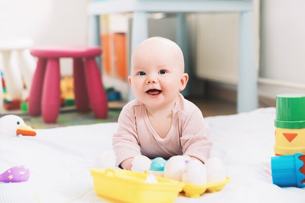 Glimlachend schattigste baby spelen met kleurrijk speelgoed Gelukkig 6 maanden oud baby kind spelen en ontdekken