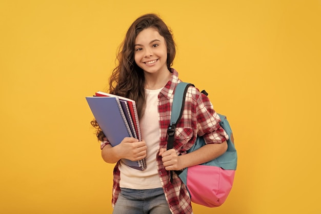 Glimlachend school tienermeisje klaar om te studeren met rugzak en notebooks onderwijs