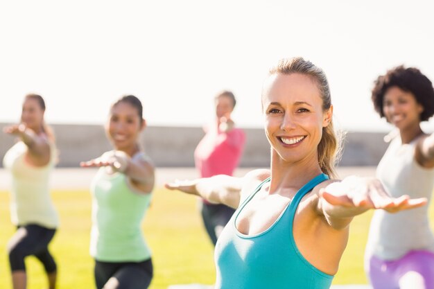 Glimlachend sportief blonde die yoga in yogaklasse doen