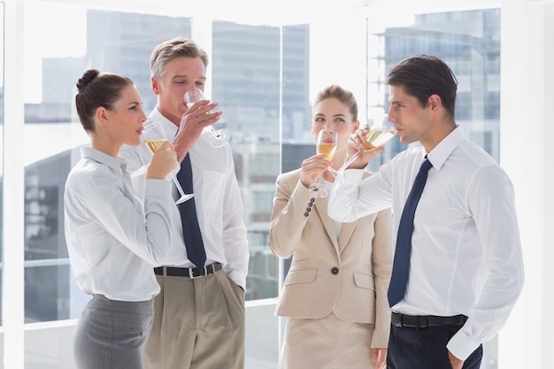 Glimlachend team van bedrijfsmensen die champagne drinken