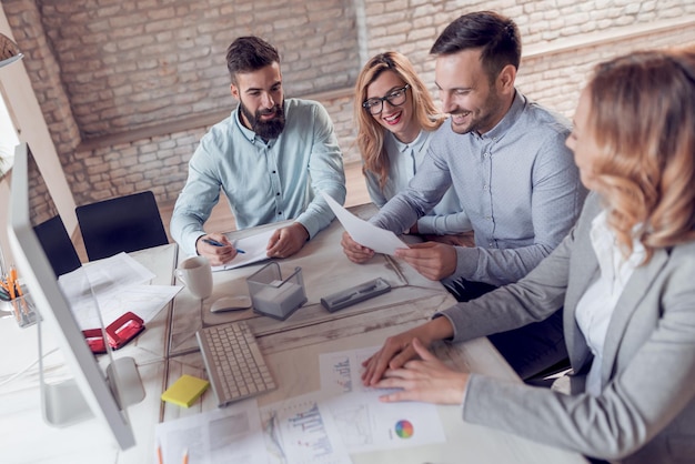 Glimlachend team van mensen uit het bedrijfsleven die samenwerken in bedrijf