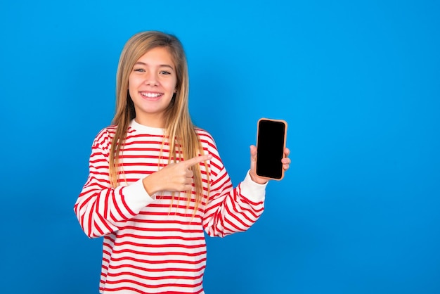 Glimlachend tienermeisje dat en wijst naar het lege telefoonscherm Advertentie en communicatieconcept