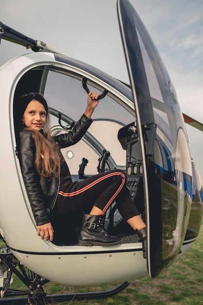 Glimlachend tussen meisje zittend op de stoel van de copiloot in een helikopter