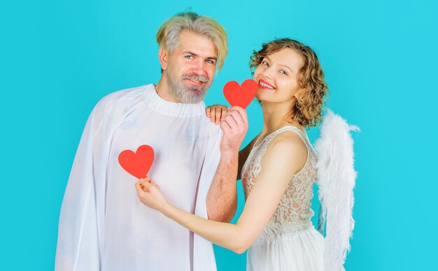 Glimlachend valentijnspaar met papieren harten engelen met witte vleugels liefdesrelaties