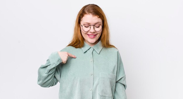 Glimlachend vrolijk en nonchalant naar beneden kijkend en wijzend naar de borst