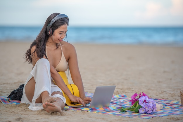 Glimlachende aantrekkelijke Aziatische vrouw met geluk en het genieten van op het strand