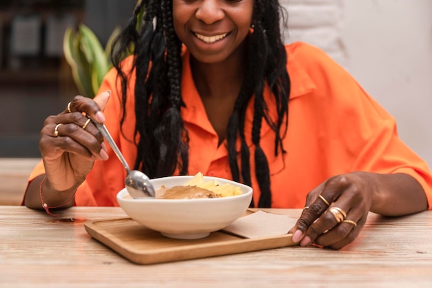 Glimlachende afro-amerikaanse vrouw die gezonde acaikom eet Organische rauwe veganist gezond