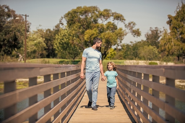 Glimlachende alleenstaande vader die een klein kind leidt buiten het ouderschap