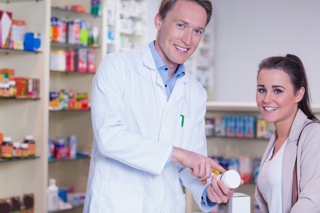 Glimlachende apotheker die de pillen verklaart aan patiënt