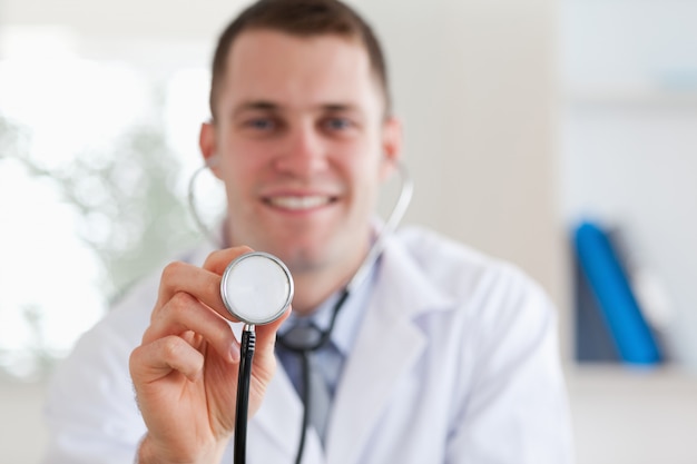 Glimlachende arts die stethoscoop met behulp van