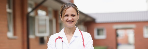 Glimlachende arts in witte jas met stethoscoop op straat medische beroepen concept