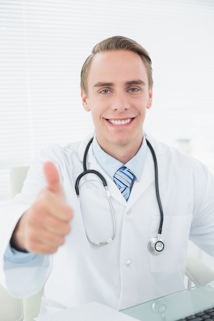 Glimlachende artsen gesturing duimen omhoog op medisch kantoor