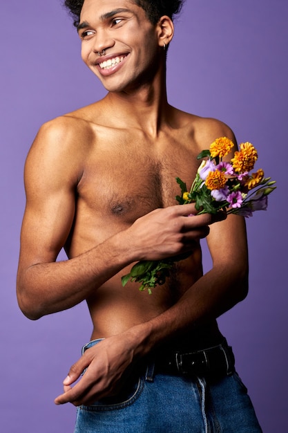 Glimlachende atletische transgender man met bloemen close-up portret shot naakte torso sportman