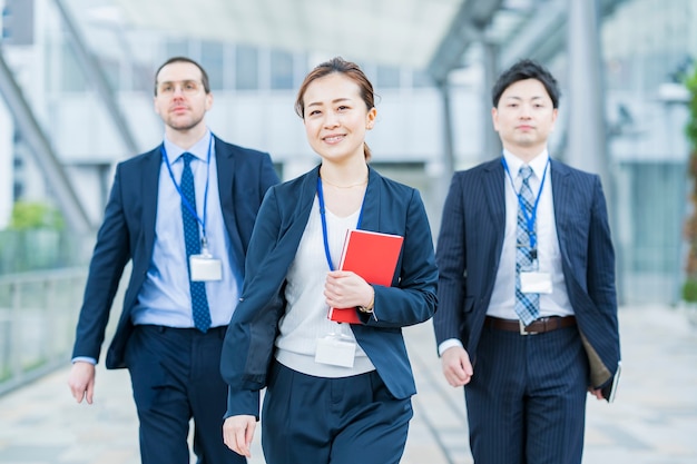 Glimlachende Aziatische bedrijfsvrouw en haar commercieel team