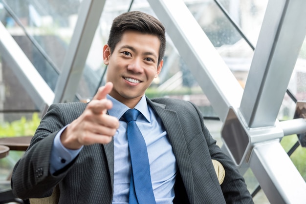 Glimlachende Aziatische zakenman zitten in de lounge van het kantoor