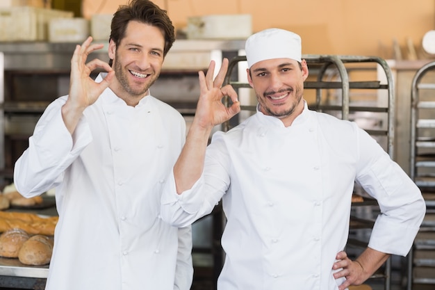 Glimlachende bakkers die camera bekijken