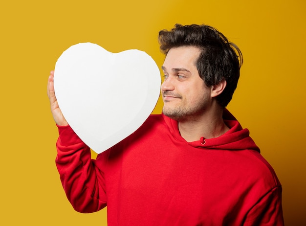 Glimlachende blanke man in rood sweatshirt met mockup in hartvorm