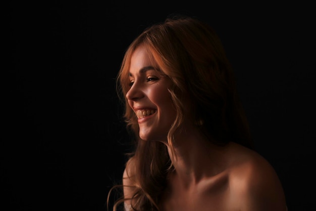 Glimlachende blonde vrouw in de schaduw Studio shot