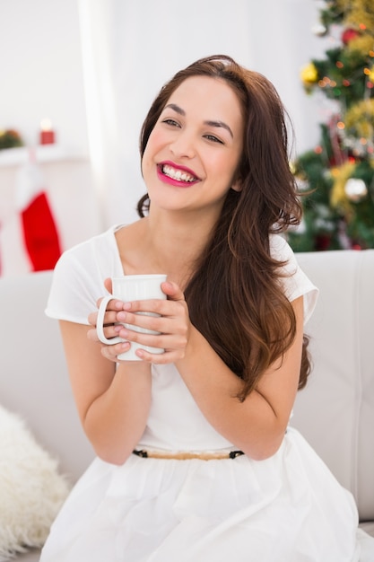 Glimlachende brunette die een mok houdt