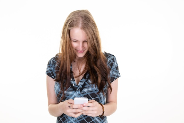 Glimlachende charmante leuke vrouw met lang blond haar met smartphone mobiele telefoon geïsoleerd op witte achtergrond in studio