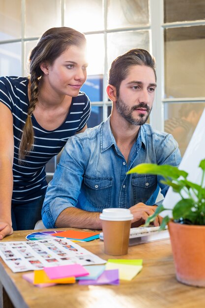 Glimlachende collega&#39;s die aan computer samenwerken