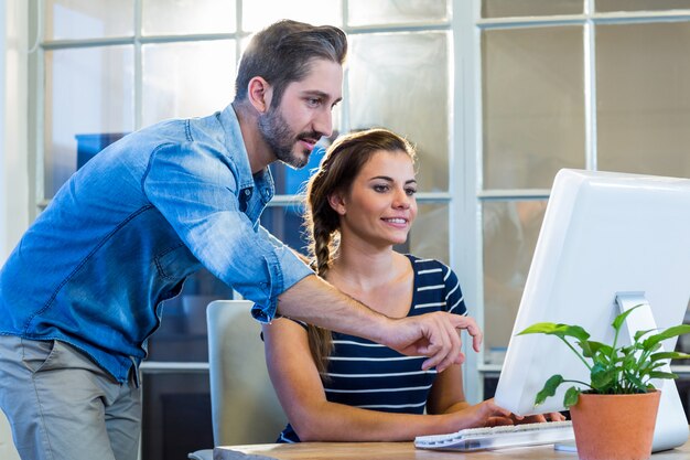 Glimlachende collega&#39;s die aan computer samenwerken