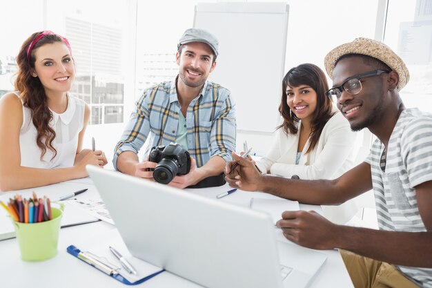 Glimlachende collega&#39;s die met digitale camera werken