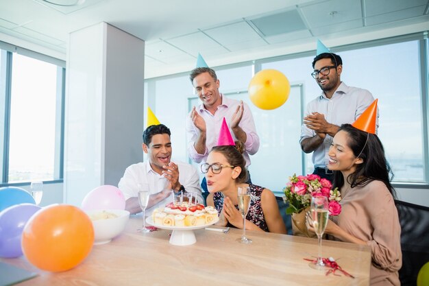 Glimlachende collega's die verjaardag van de vrouw vieren