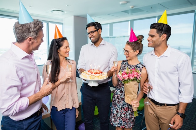 Glimlachende collega's die verjaardag vieren