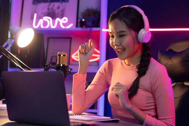 Glimlachende creatieve jonge mooie Aziatische influencer die praat in kanaal Stratagem
