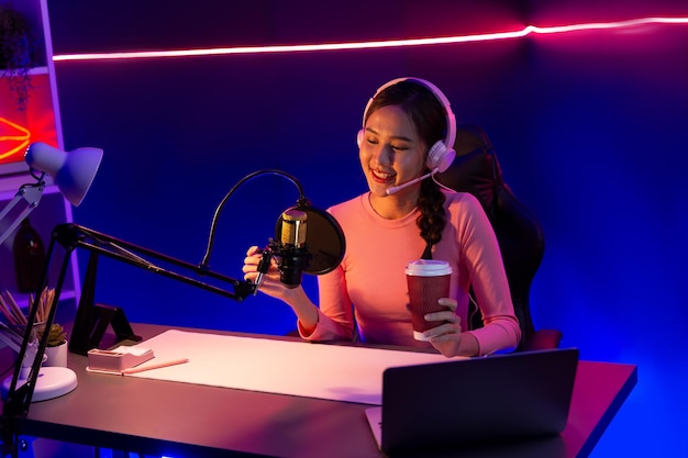 Glimlachende creatieve jonge mooie Aziatische influencer praat in kanaal stratagem